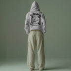 minimalist-studio-hoodie-mockup-back-view-male-model-wearing-beige-cargo-pants-against-muted-green-backdrop-0648