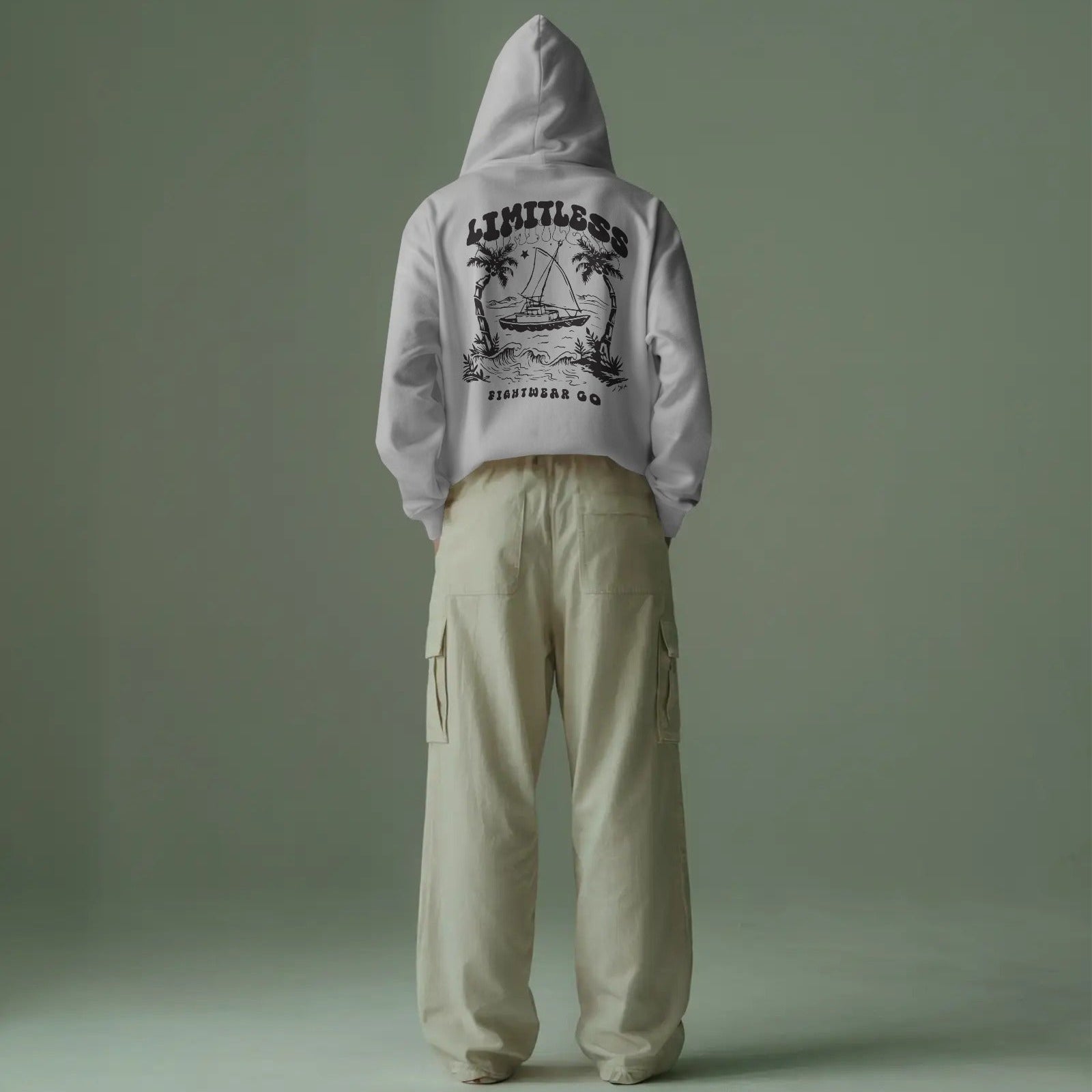 minimalist-studio-hoodie-mockup-back-view-male-model-wearing-beige-cargo-pants-against-muted-green-backdrop-0648